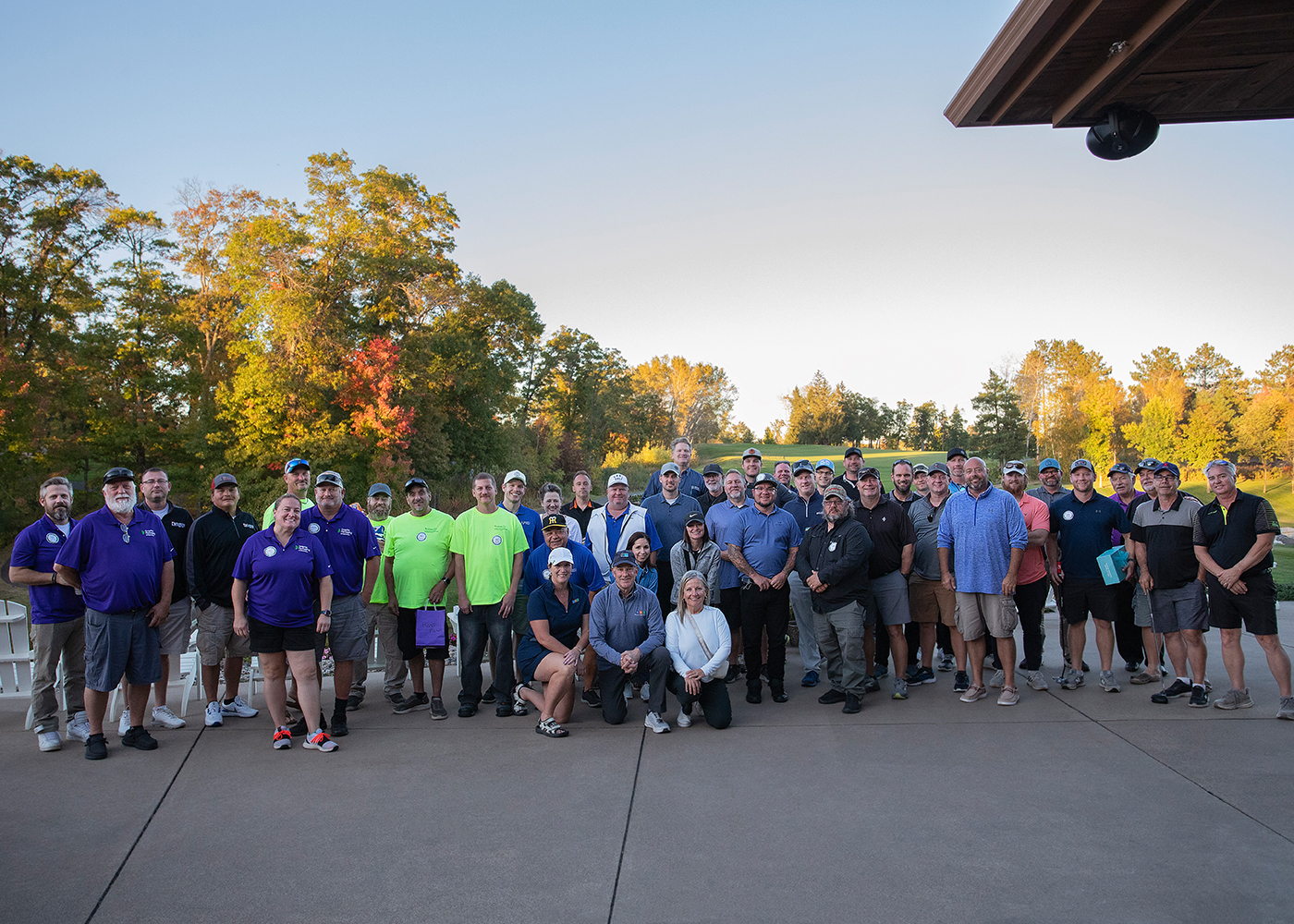 group photo of golf outing participants outside the club house